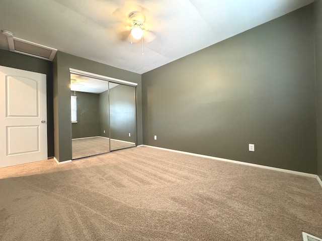 unfurnished bedroom featuring ceiling fan, carpet flooring, a closet, and vaulted ceiling