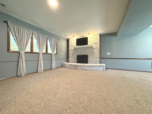 unfurnished living room featuring a wood stove and carpet flooring