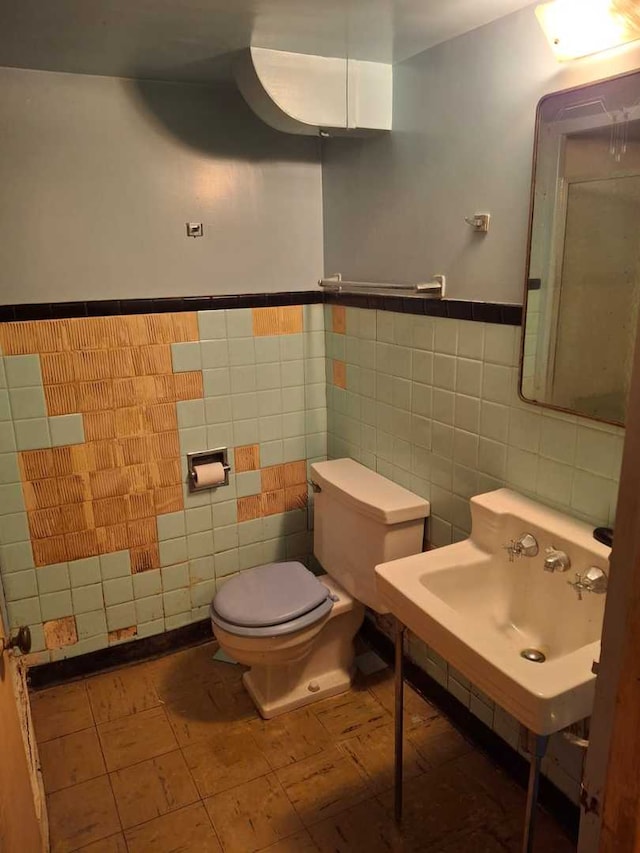 bathroom featuring tile walls and toilet