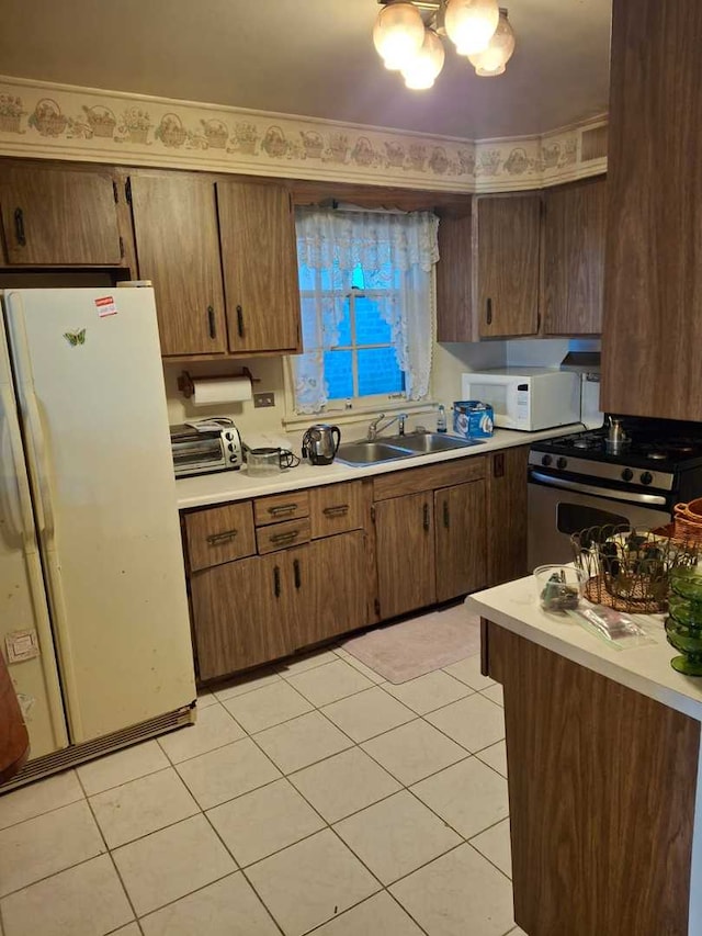 kitchen with light tile patterned floors, white appliances, and sink