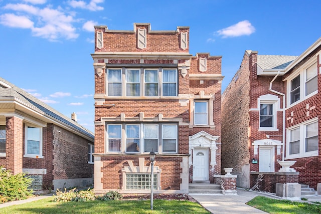 townhome / multi-family property featuring a front lawn