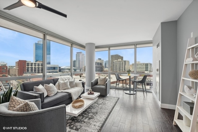 living room featuring wood-type flooring, a healthy amount of sunlight, and a wall of windows