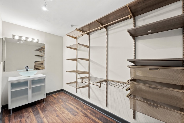 walk in closet with dark hardwood / wood-style flooring and sink