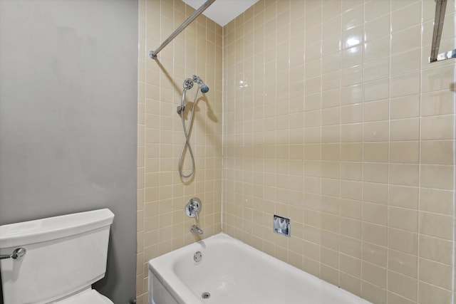 bathroom featuring tiled shower / bath combo and toilet