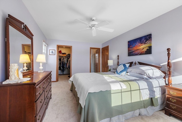 carpeted bedroom with a spacious closet, ceiling fan, and a closet