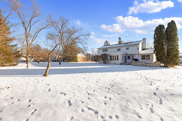 view of snow covered back of property