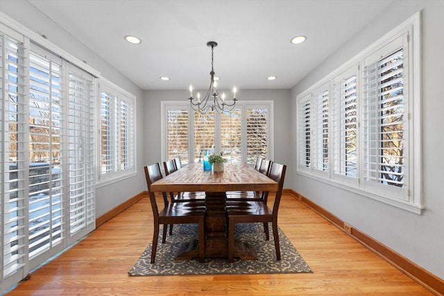 dining space featuring light wood-type flooring and an inviting chandelier