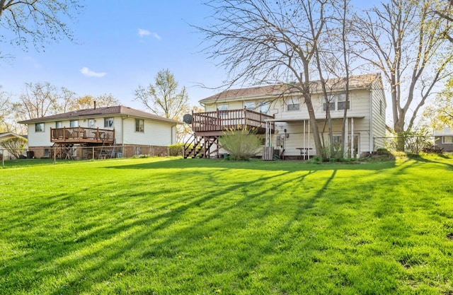 rear view of house with a deck and a yard