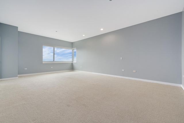 spare room with recessed lighting, light carpet, and baseboards