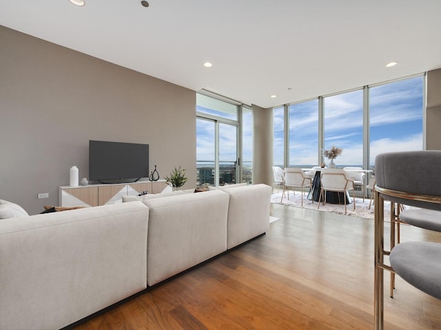 living area featuring floor to ceiling windows, wood finished floors, and recessed lighting