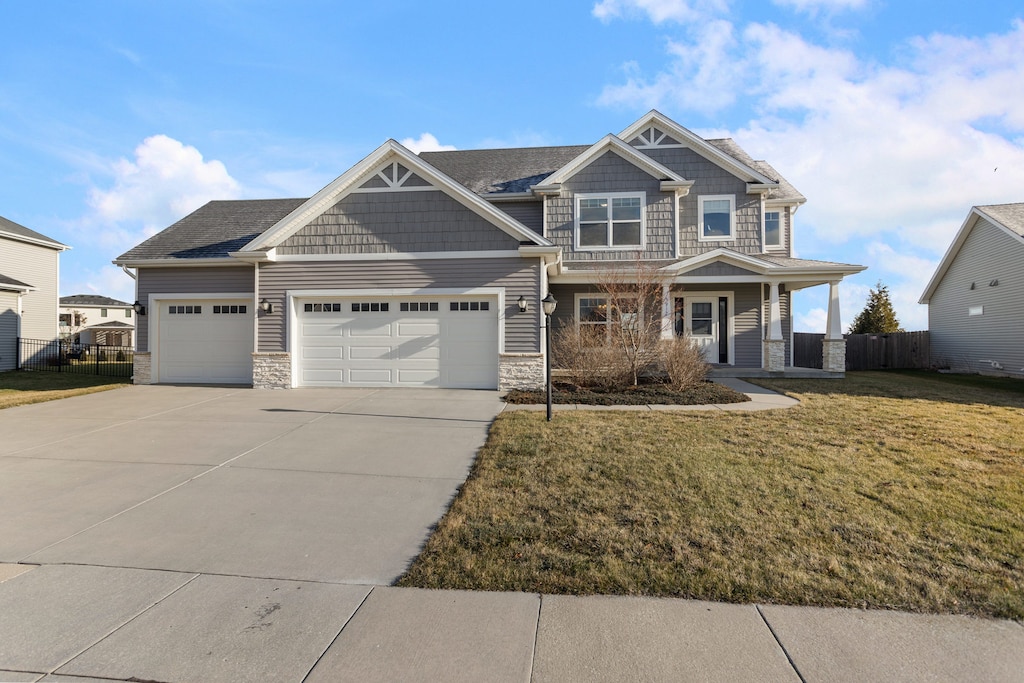 craftsman house featuring a porch, a garage, and a front lawn