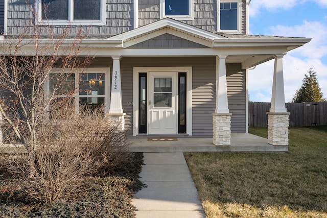 doorway to property with a yard and a porch