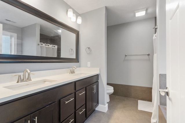 bathroom with tile patterned floors, vanity, and toilet