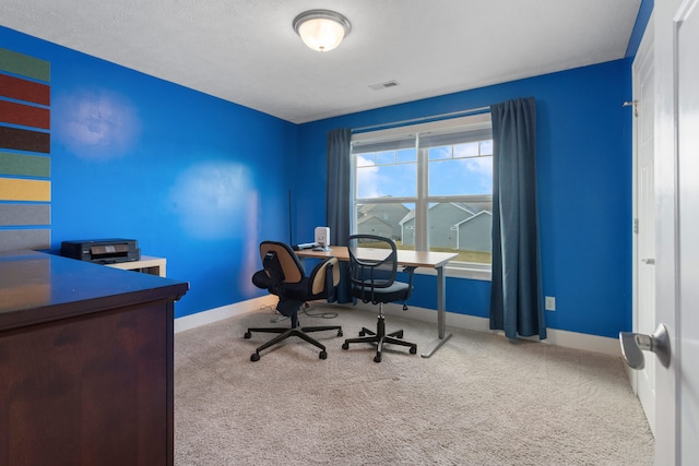 home office featuring carpet floors and a textured ceiling