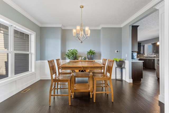 dining area with a notable chandelier, plenty of natural light, and crown molding