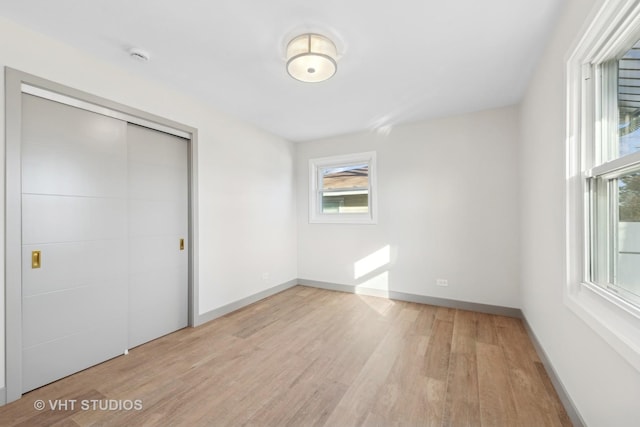 unfurnished bedroom with a closet and light wood-type flooring