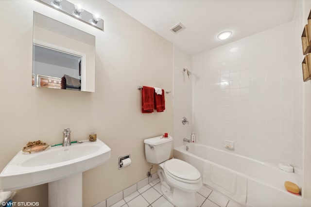 bathroom featuring tiled shower / bath combo, tile patterned floors, and toilet