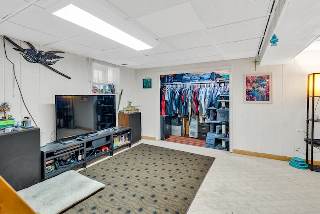 living room featuring carpet floors and a drop ceiling