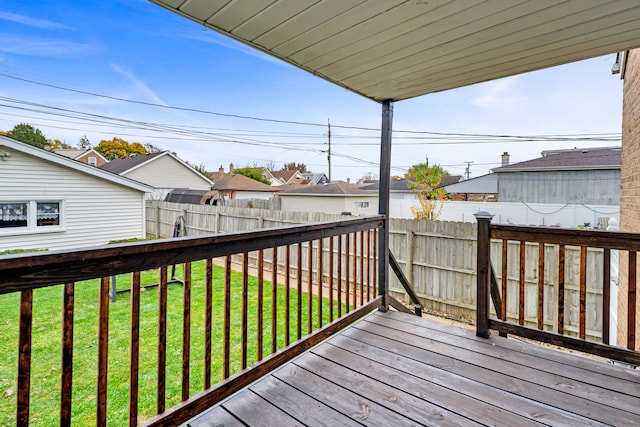 wooden deck featuring a lawn