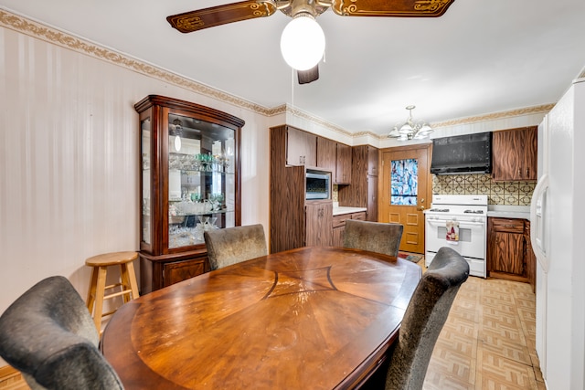 dining space with ceiling fan with notable chandelier and light parquet flooring