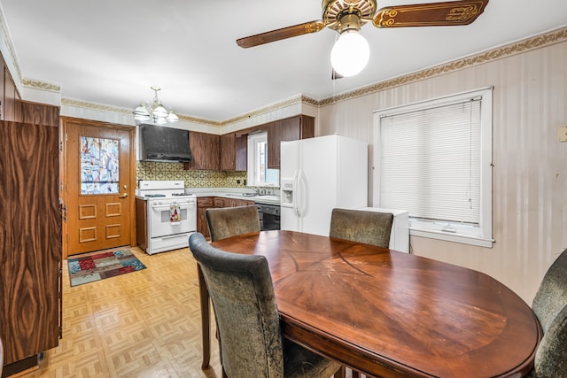 dining room featuring ceiling fan with notable chandelier, sink, and light parquet floors