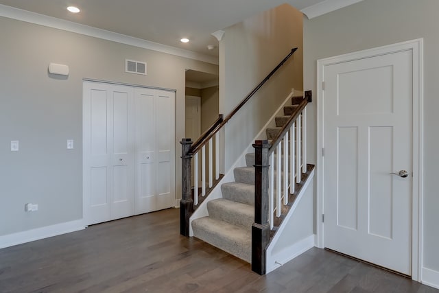 staircase with wood-type flooring and crown molding