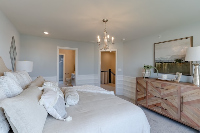 bedroom featuring light colored carpet, a notable chandelier, and connected bathroom