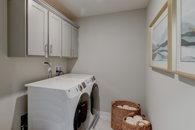 clothes washing area featuring washing machine and dryer and cabinets