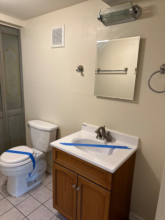 bathroom featuring vanity, tile patterned flooring, and toilet