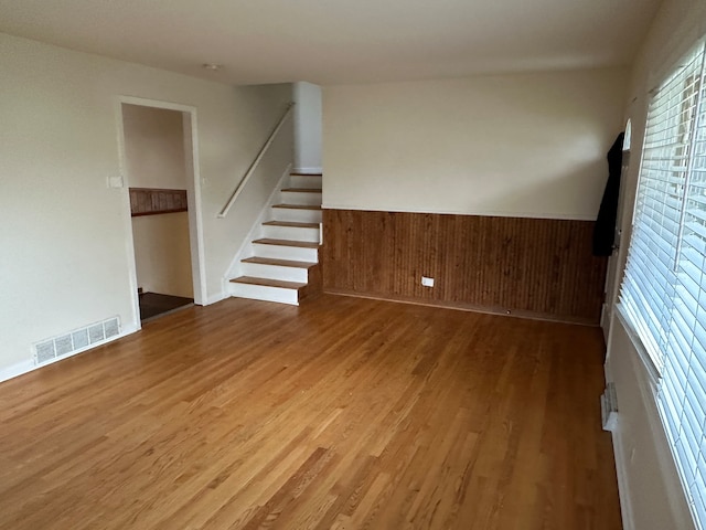 unfurnished room featuring wood walls and hardwood / wood-style flooring