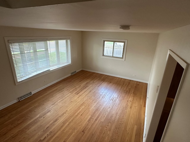 empty room featuring hardwood / wood-style floors and vaulted ceiling