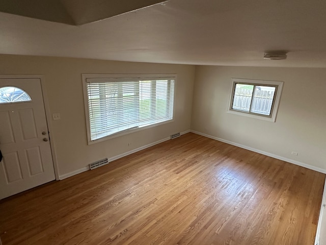 foyer featuring lofted ceiling, hardwood / wood-style floors, and plenty of natural light