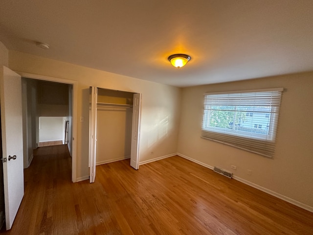 unfurnished bedroom featuring hardwood / wood-style flooring and a closet