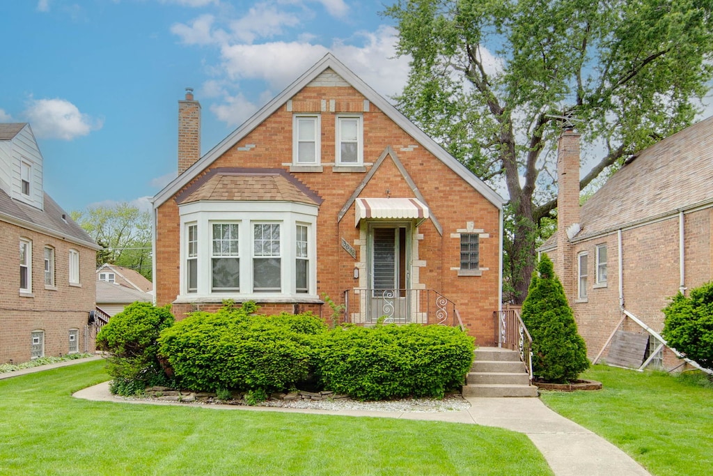 english style home with a front lawn