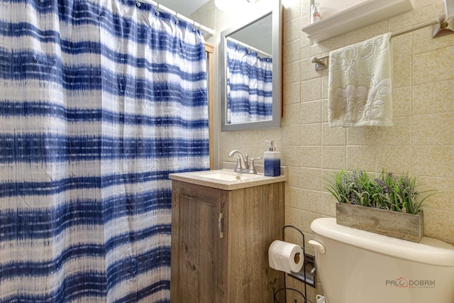 bathroom featuring tile walls, vanity, toilet, and a shower with shower curtain