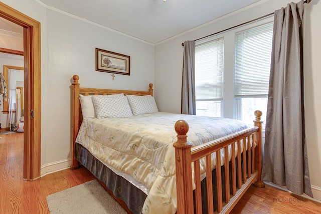 bedroom with ornamental molding and light hardwood / wood-style floors