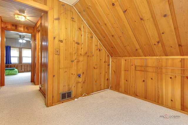 bonus room featuring wood ceiling, vaulted ceiling, light carpet, wooden walls, and ceiling fan