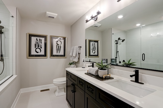 bathroom with vanity, toilet, and a shower with door