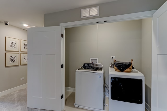 clothes washing area featuring separate washer and dryer and light colored carpet