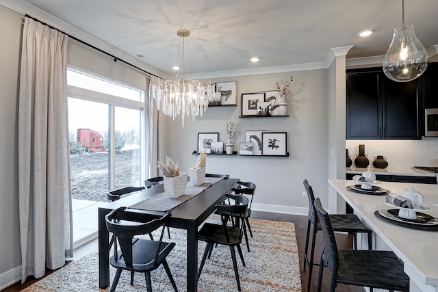 dining space with ornamental molding, a notable chandelier, and wood-type flooring