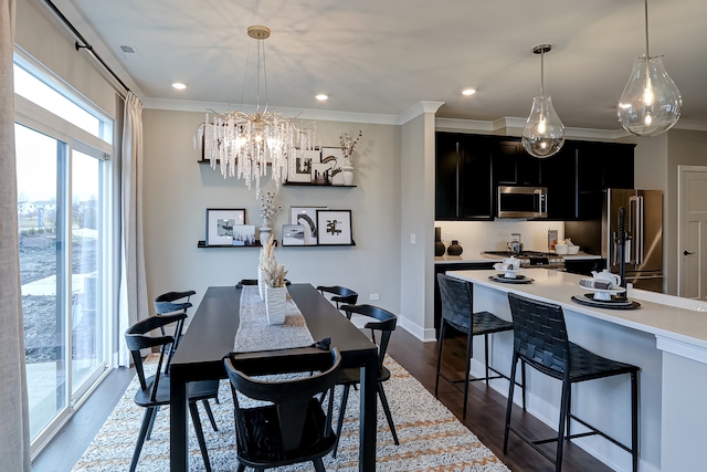 dining room with ornamental molding, dark hardwood / wood-style floors, and an inviting chandelier