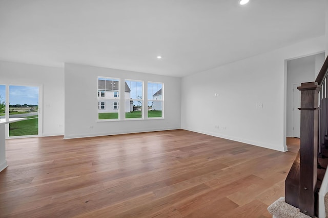 unfurnished living room with plenty of natural light and light hardwood / wood-style floors