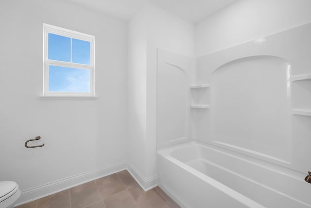 bathroom with shower / bathing tub combination, tile patterned flooring, and toilet