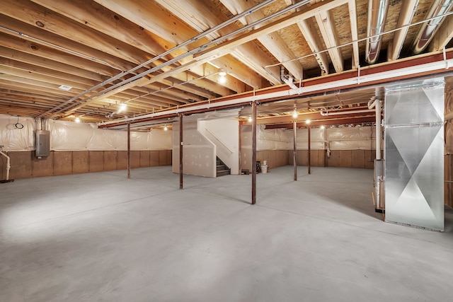 basement with electric panel and heating unit