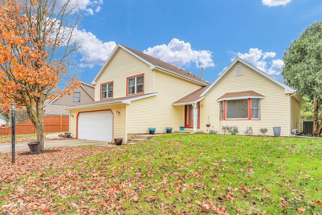 view of property with a front lawn, central AC unit, and a garage