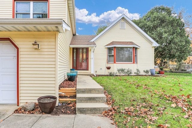 property entrance with a garage and a yard