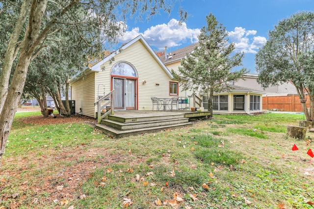 rear view of house with a lawn and a wooden deck