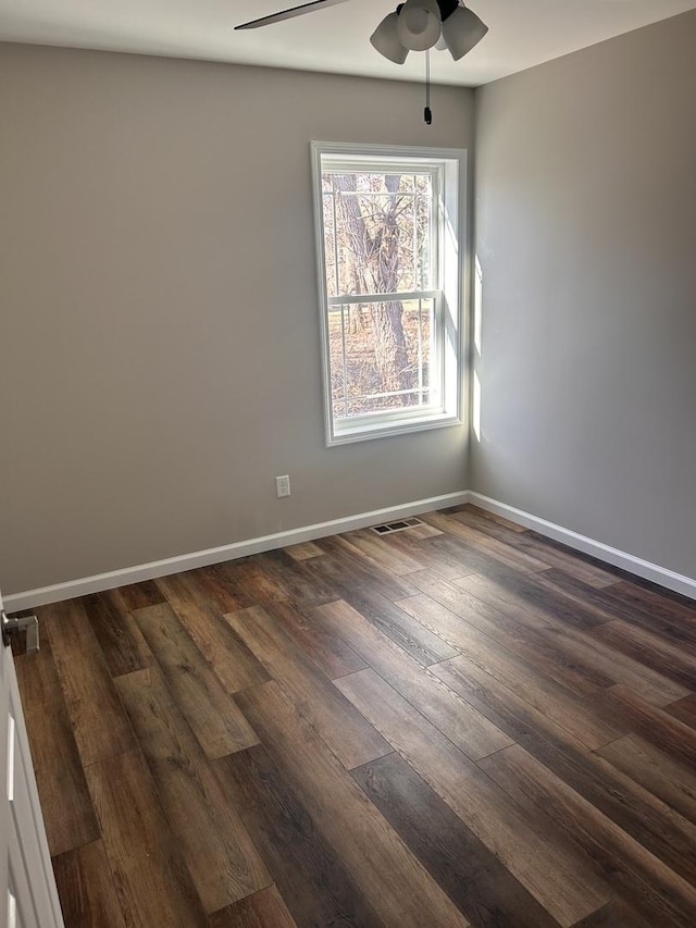 empty room with dark wood-type flooring and ceiling fan