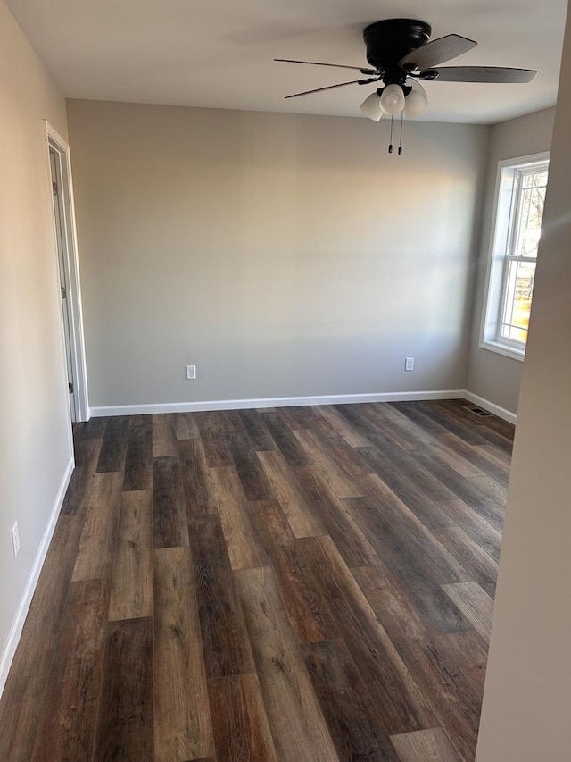 unfurnished room featuring dark wood-type flooring and ceiling fan