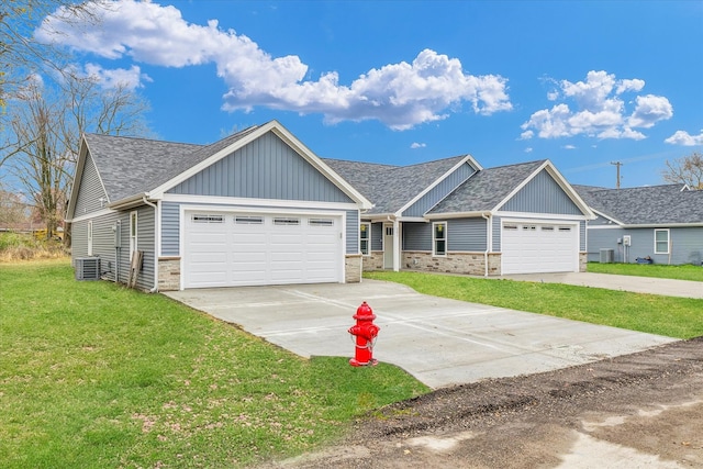 view of front of property featuring a garage, central AC unit, and a front yard